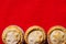 Traditional English Christmas dessert pastry mince pies in muffin tins sprinkled with sugar on crimson red table cloth