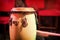 Traditional ethnic Cuban Djembe drum on red background. Percussion instruments made of wood covered with leather. Ethnic drum set