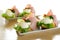 Traditional European open egg and ham sandwiches on white ceramic plates.