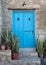 Traditional exterior house courtyard with blue wooden door and p