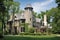 traditional exterior of tudor-style house, complete with turret, cast stone columns and decorative half-timbering