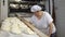 Traditional family Italian bakery. A woman baker prepares bread for baking.