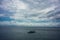 Traditional fisherboat sailing on water with cloudy sky