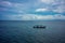 Traditional fisherboat sailing on water with cloudy sky