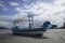 Traditional fishing boat laying on a beach near the sea with cloud and blue sky in background, dramatic colourful picture style