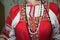 Traditional folk ornaments on a red sundress of a woman decorated with a beautiful national ornament. Clothing, jewelry