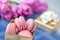 Traditional French colored almonds lie in rows in a gift box on the background of a bouquet of flowers. Close-up, selective focus