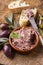 Traditional French goose pate as spread in a bowl with baguette and olives on a rustic wooden board