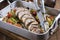 Traditional French lamb rolled roast sliced with potatoes and vegetables in a design aluminum pan