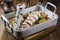 Traditional French lamb rolled roast sliced with potatoes and vegetables in a design aluminum pan