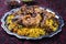 Traditional fried Arabic chicken majboos with chicken leg and jeweled rice in a rustic oriental tray