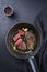 Traditional fried dry aged bison beef rump steaks with herbs and garlic in a rustic metal skillet