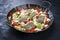 Traditional fried Greek skrei cod fish filet casserole with feta cheese and vegetable in a rustic wrought iron pan