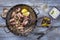 Traditional fried octopus with tzatziki and kalamata olives in a cast iron pan on a wooden blue table