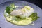 Traditional fried skrei cod fish filet with mashed potato cream and coriander lime relish on Nordic design plate