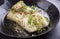 Traditional fried skrei cod fish fillet with spice and cress in a rustic wrought-iron pan