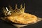 Traditional galette des Rois with decorative crown on black table