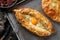 Traditional Georgian cheese bread on a dark background, close up view. Baked open pie with cheese and egg yolk filling