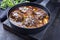 Traditional German braised beef cheeks in brown red wine sauce with carrots and onions in a cast iron Dutch oven