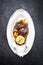 Traditional German braised pork cheeks in brown red wine sauce with fried mushed potatoes and pumpkin