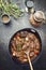 Traditional German braised pork cheeks in brown sauce with mushroom and carrots in a stew pot