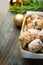 Traditional German Christmas pastry mini stollen in wicker basket on plank wood table. Fresh green juniper branch golden ornament