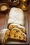 Traditional German Christmas stollen with raisins, nuts, candied fruits, sliced, powdered, festive table setting, lit candle, siev