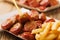 Traditional German currywurst, served with chips on disposable paper tray