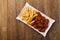 Traditional German currywurst, served with chips on disposable paper tray