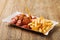 Traditional German currywurst, served with chips on disposable paper tray