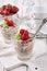 Traditional German muesli dessert with strawberries joghurt with flakes and nuts in a glass