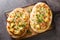 Traditional German pizza with cheese, potatoes, onions and bacon close-up on a wooden board. horizontal top view