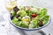 Traditional German summer lettuce with curled lettuce, goat cheese and mango dressing in a bowl on a well laid table