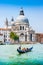 Traditional Gondola on Canal Grande with Basilica di Santa Maria della Salute in Venice, Italy