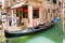 Traditional gondola on a narrow canal in Venice, Italy