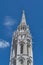 Traditional gothic church steeple over cloudy blue skies