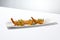 Traditional greek appetizer - kataifi wrapped shrimps on white plate. Crispy shrimp in kataifi crust in summer day. Shrimp
