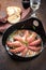 Traditional Greek octopus braised cooked with tomatoes and herbs in ouzo sauce in a cast-iron saucepan