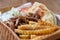 Traditional Greek souvlaki meat and pita served with white tzatziki sauce and French fries in recyclable paper plate for take away