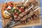 Traditional Greek souvlaki skewer with feta cheese and pita bread on a wooden cutting board