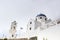 Traditional Greek white church arch with cross and bells in Santorini Greece