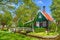 Traditional green dutch house with little wooden bridge against blue sky in the Zaanse Schans village, Netherlands. Famous tourism