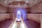 Traditional hammam sauna with modern colored lighting and stone washbasin