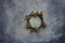 Traditional Handmade Christmas Wreath Green Fir Tree Branches Twigs Holly Berries on Grungy Dark Stone Background. Top View