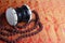 Traditional hindu prayer beads rudraksha and musical instrument of God Shiva Damaru drum on a red saree background