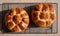 Traditional home cooked Jewish Challah bread loaves, on a wire tray. One is topped with nigella seeds and the other with rosemary.