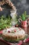 Traditional homemade Christmas cake with garnish cranberry and rosemary on decorative plate. Powdering with icing sugar.