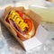 Traditional hot dog with a smoked frankfurter on a fresh roll garnished with mustard and served with lettuce, tomato and