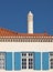 Traditional house facade in blue white with typical chimney