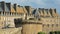 Traditional house facades with chimneys and roofs, located inside the walled city of Saint Malo, with the ramparts in the foregrou